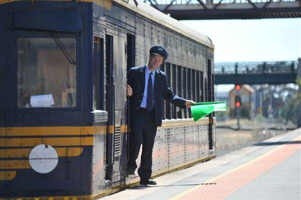 historic: Conductor Colin Sharp steps off the Diesel Electric Rail Motor train and onto the platform at Bendigo. Picture: MATT KIMPTON