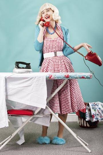 Retro housewife talking on the phone and ironing