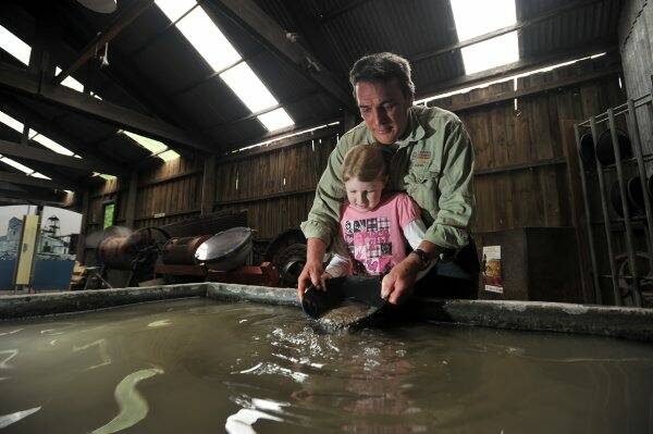 HOPING: Maeya Verhagen, 7, tries her hand at gold panning with help from Central Deborah Gold Mine guide John McNamara.