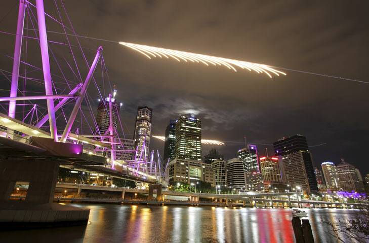 Two Super Hornets fly past the city skyline at the start of Brisbane Riverfire seen from the South Brisbane end of the Kurilpa Bridge.