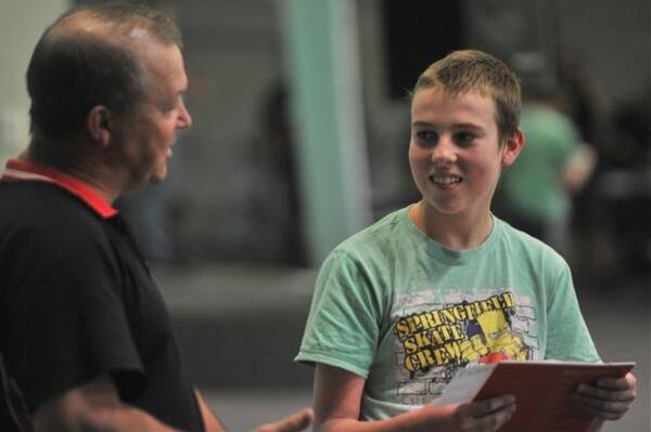 HELPING HAND: Lachlan Lucas receives a private swimming lesson grant from YMCA’s Paul Johns. 