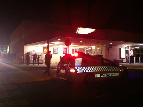 CRIME SCENE: Police gather at the Safeway Liquor store at Centro Plaza tonight. Picture: CHLOE ROSS