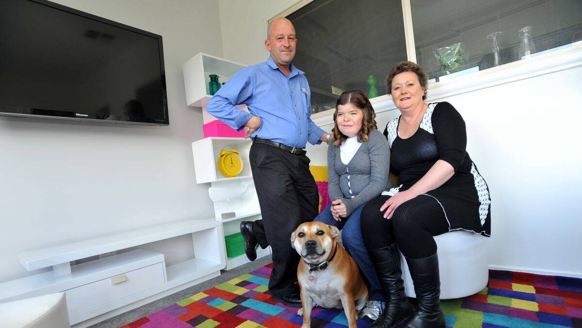 NEW DIGS: Alayna Campbell with her parents Malcolm and Rayleen and the family dog Ruby in Alayna’s newly made over room, thanks to the Starlight Foundation.Picture: JULIE HOUGH