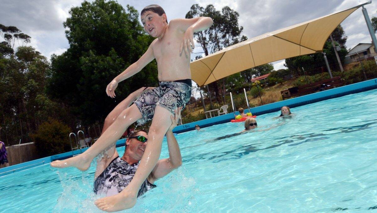 Splash: Bailey, 11, and dad John Simsen take a dip at Chewton pool yesterday. Picture: BRENDAN McCARTHY