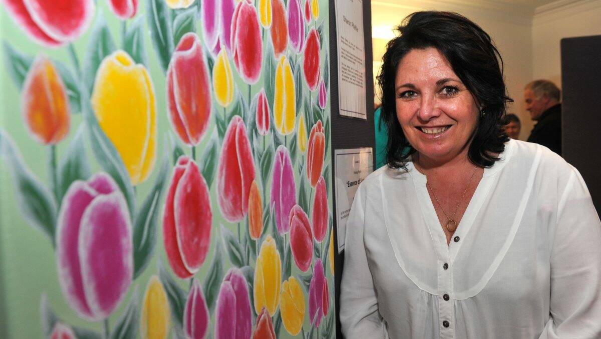 BRIGHT: Sharon Pfieffer from GeJay Automotive with her painting ‘Essence of Spring’ at the Vision Australia Art Show last night. Picture: JODIE DONNELLAN