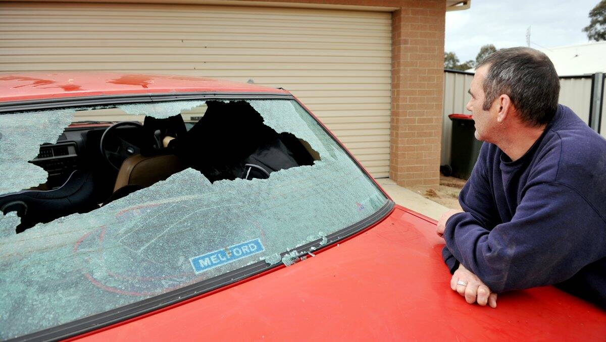 Aftermath: Billy Thow shows the damage caused to his garage door and car. Picture: JULIE HOUGH