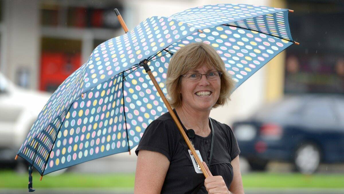 OUT AND ABOUT: Julie Flynn stays dry during yesterday's rain. Picture: JIM ALDERSEY