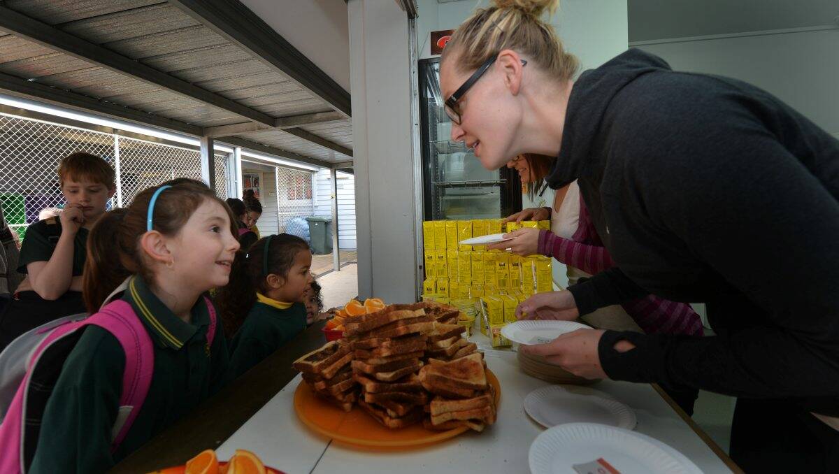 YUM: Basketballer Chelsea Aubry dishes up a healthy breakfast to Spring Gully Primary student Natasha Hayes. Picture: Brendan McCarthy