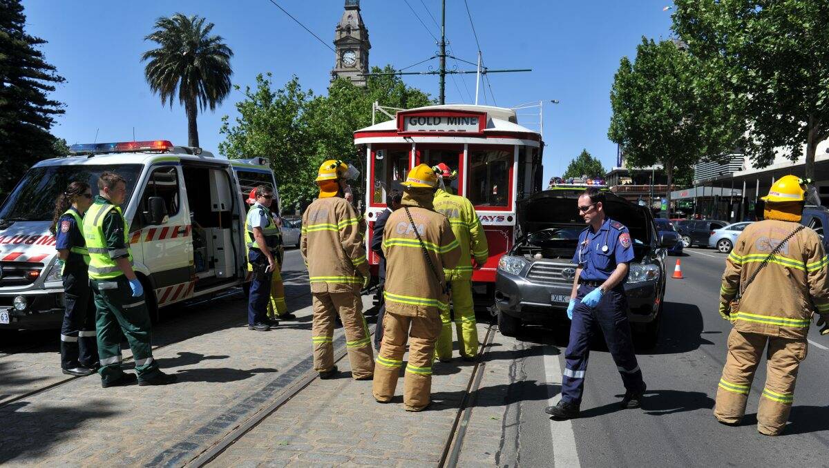 SMASH: Emergency workers attend the scene of a collision between a Toyota Kluger and a tram. Picture: JULIE HOUGH