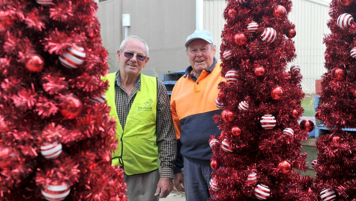 Christmas spirit: Foodbank volunteers Gordon Scott and Mick Crowley with some of the donated Christmas trees.Picture: Jodie Donnellan