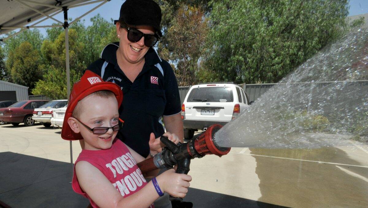 Fun day: Above, Krystal Widdows shows four-year-old Dylan Mathieson how to work a fire hose.Picture: Julie Hough