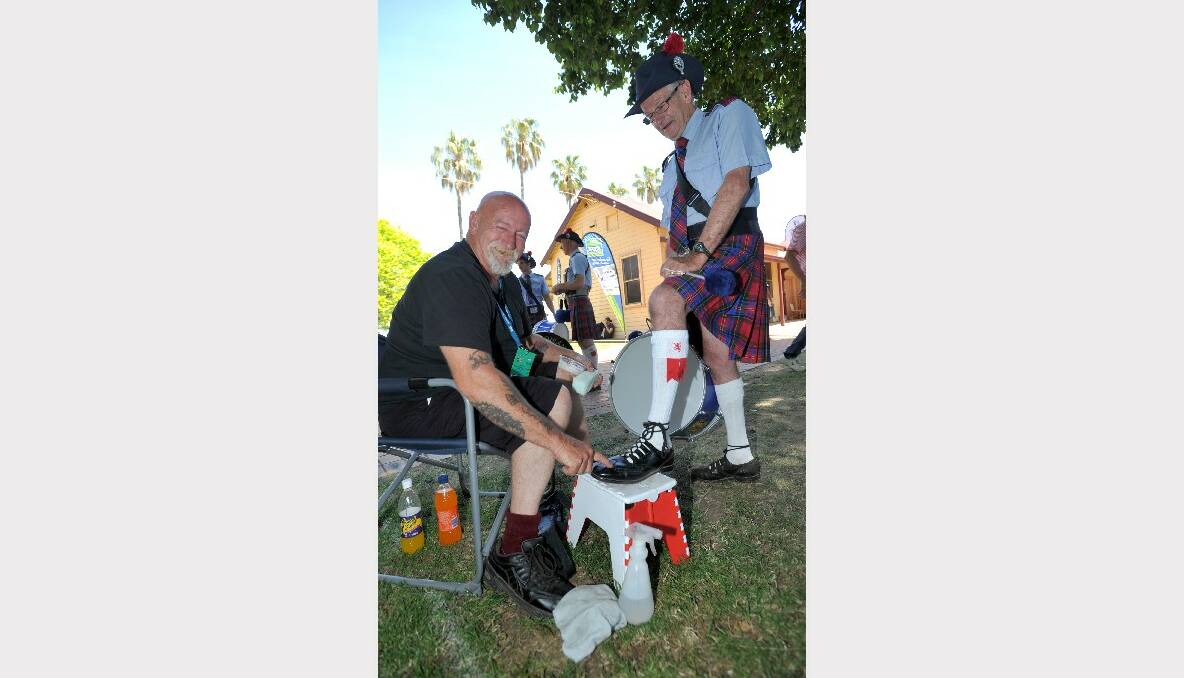 Peter Heritage from the Bendigo Highland Pipe Band has a shoe shine at Colin Wilson's Wonder Wax stall. 