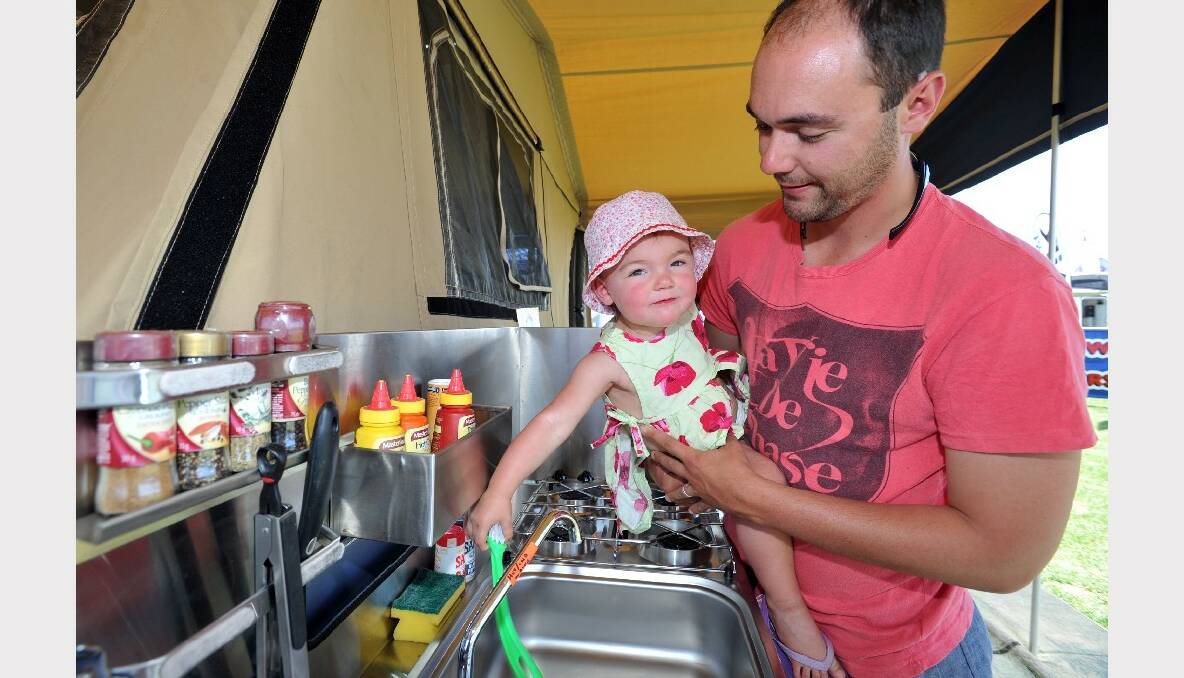 Matt Bender and his 18 month old daughter Charlee, from Lancefield, check out a camper trailer. 