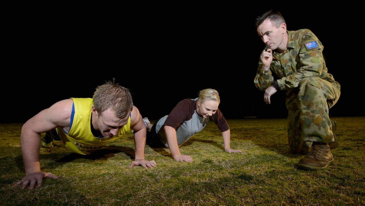 HARD YAKKA: Huntly’s Stacy Fiske and Megan Smart are put through their paces by the Army Reserve’s Shane Duncan. Picture: MATT KIMPTON