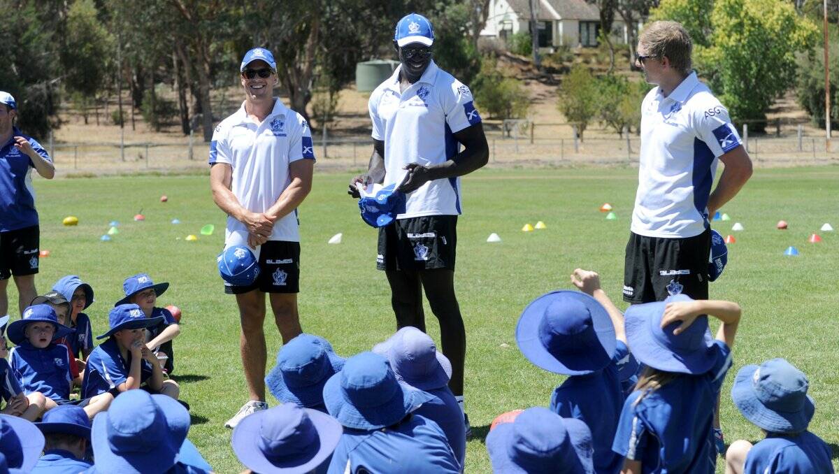 HANDY HINTS: North Melbourne captain Andrew Swallow and team-mates Majak Daw and Jack Ziebell speak to the keen youngsters before the start of yesterday's football clinic at Newstead. Picture: JODIE DONNELLAN