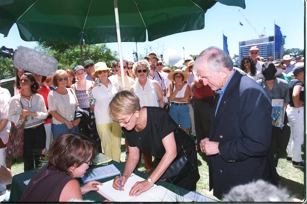 Hazel Hawke and Bryce Courtenay sign the 'Sorry Book' on National Sorry Day. Photo: Sahlan Hayes