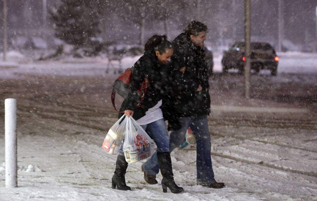 People make their way across Tesco's supermarket car park as more snow falls in Shepton Mallet in Somerset, England. Photo by Matt Cardy/Getty Images