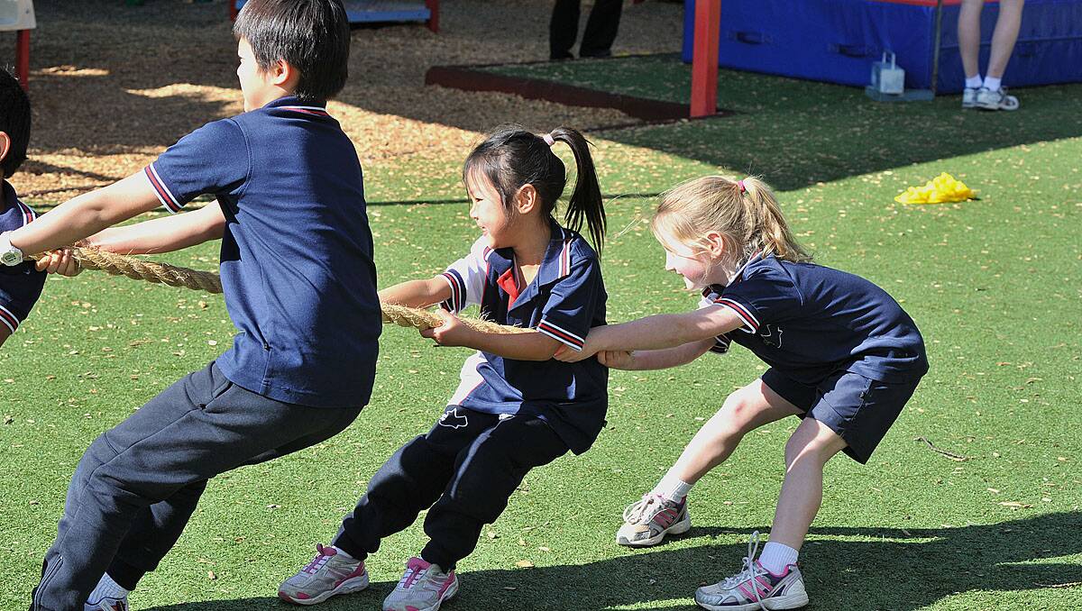 Olympics at Creek Street Christian College. Lulu Wah and Ava Wood put their weight behind the effort. Photo Peter Waeving