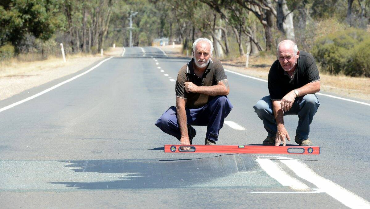 FRUSTRATED: Residents Peter Davey and Wayne Maher inspect the pothole.JIM ALDERSEY