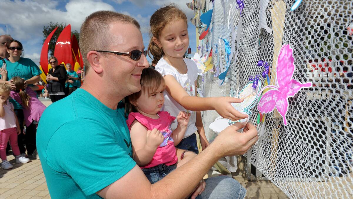 SPAN suicide awareness walk 2013. Travis Stringer and his children Chelsea and Tayla place a butterfly on the remembrance wall for a friend. Picture: Julie Hough