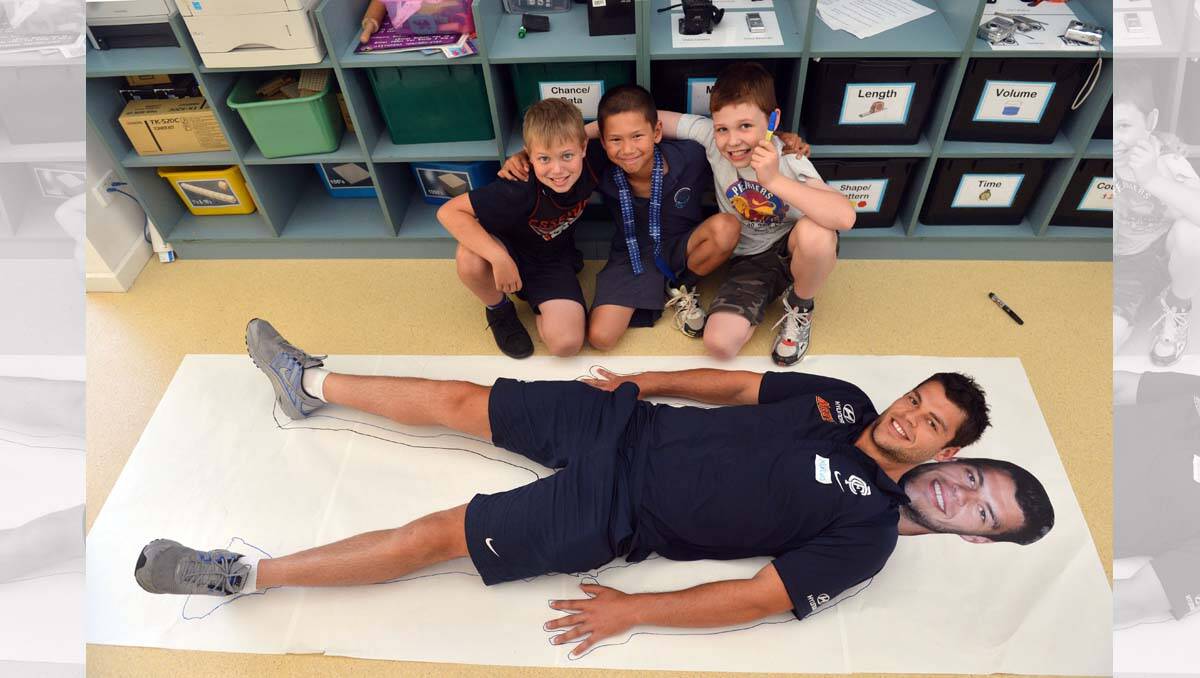 Carlton players visit Lockwood South Primary. Marcus Davies with students Ryan Cook, Yan Wen Rose and Jonathan Keating. Picture: Brendan McCarthy