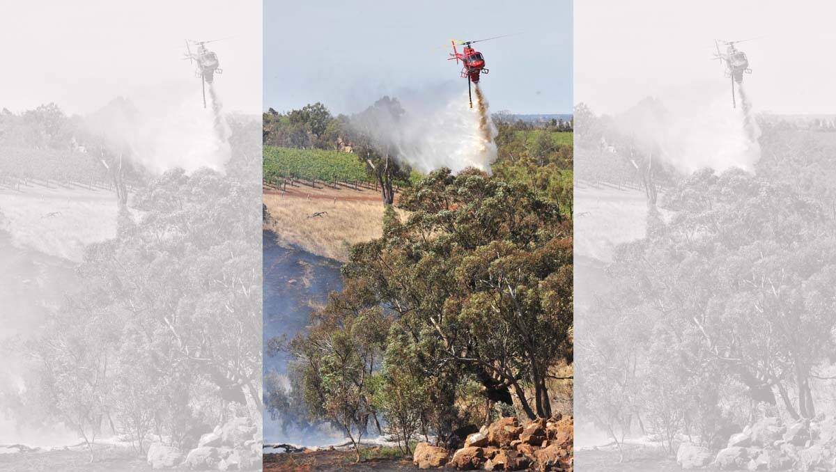 A water-bombing helicopter helps put out a grass fire at Corop. Picture: Peter Weaving