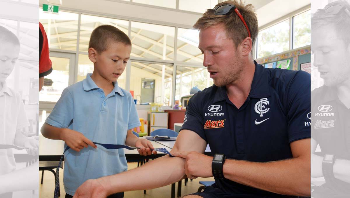 Carlton players visit Lockwood South Primary. Jeremy Laidler with student Yan Feng Ross. Picture: Brendan McCarthy