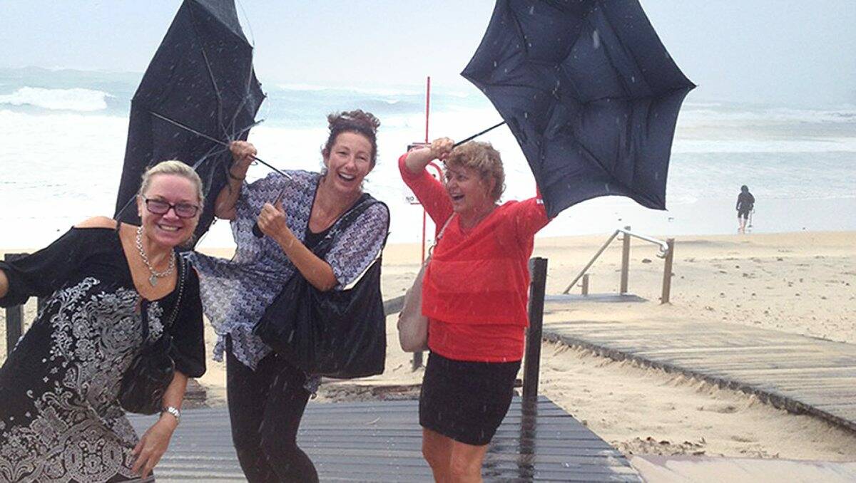 WET’N’WILD: Bendigo Advertiser reader Sue Opie sent through these two snaps of the holidaying group caught in wild weather on Noosa Heads beach. Ms Opie was able to board a flight home yesterday.
