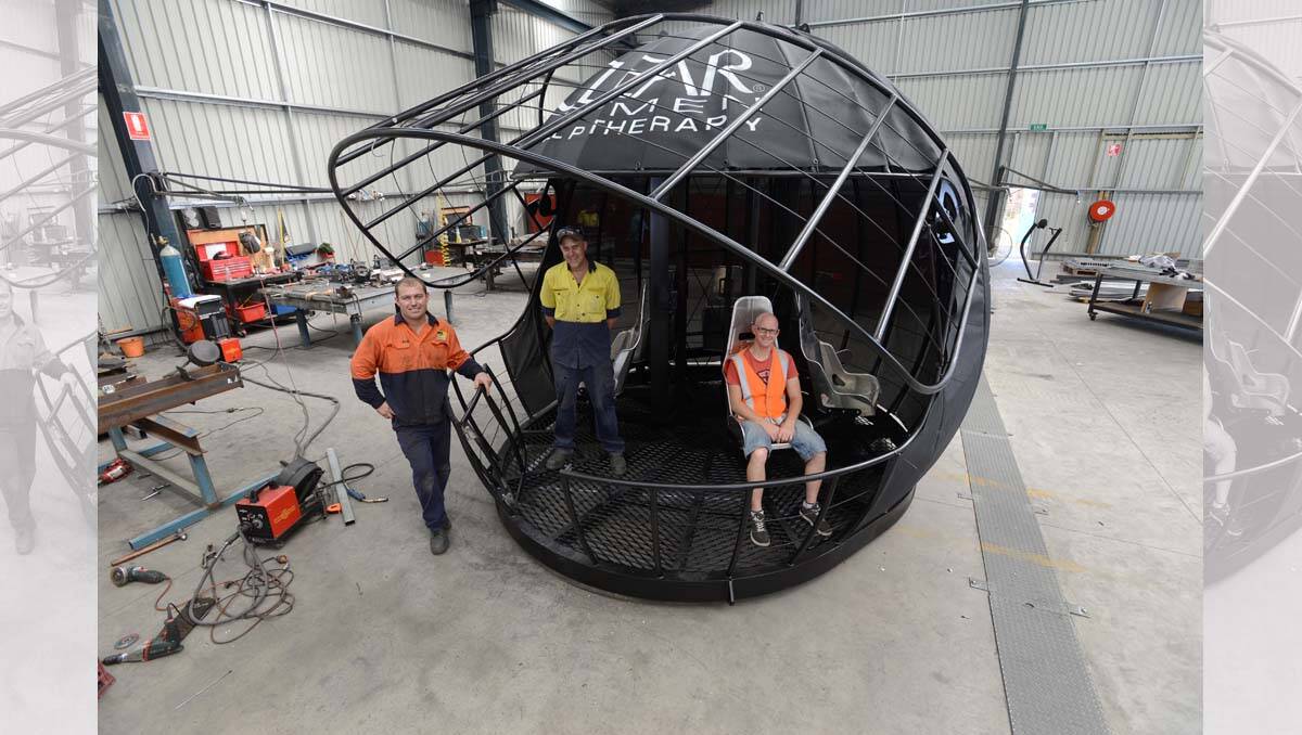 LIFT: The Australian Turntable Company’s Andrew Price, Ash Hamley and Clinton Miller with the helmet-shaped platform. Picture: JIM ALDERSEY