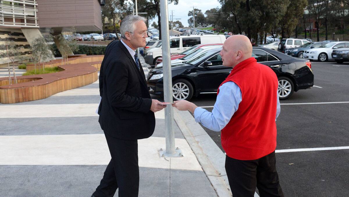 An ambulance protester hands a flyer to Damian Drum MLC outside the Community Cabinet meeting at Latrobe University.  Picture: Jim Aldersey