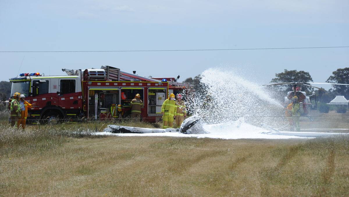 Fire crews douse the wreckage. Picture: Peter Weaving