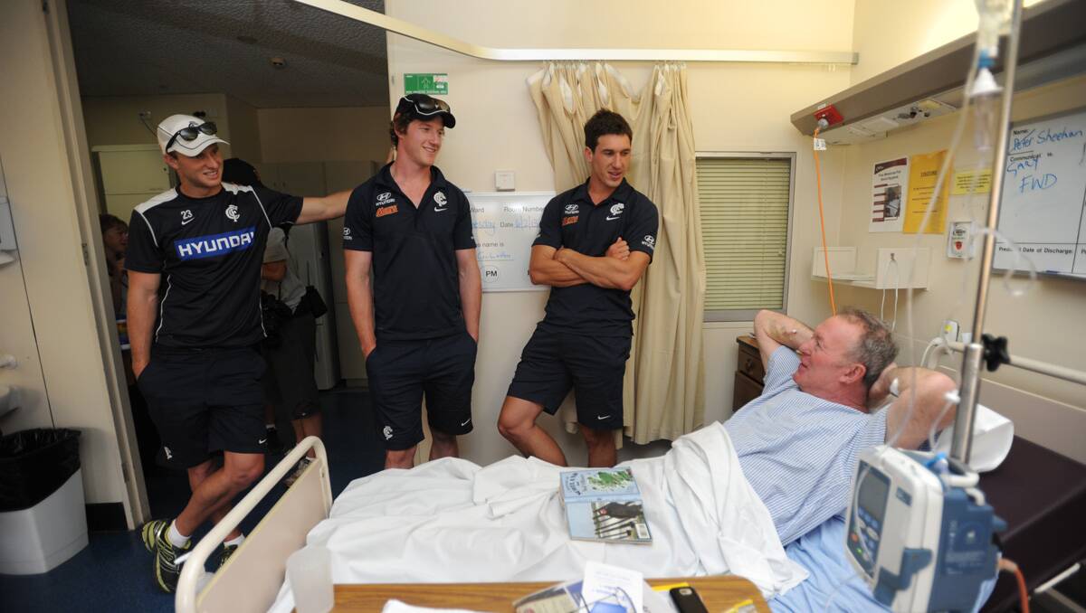 Carlton players visit Bendigo Health. Michael Jamison, Sam Rowe and Lachie Henderson visit Peter Sheehan. Picture: Jodie Donnellan