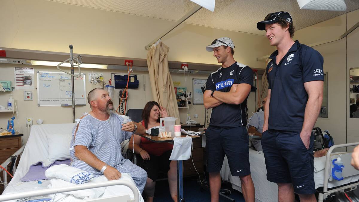 Carlton players visit Bendigo Health. Michael Jamison, Sam Rowe and Lachie Henderson visit Peter Fensham. Picture: Jodie Donnellan