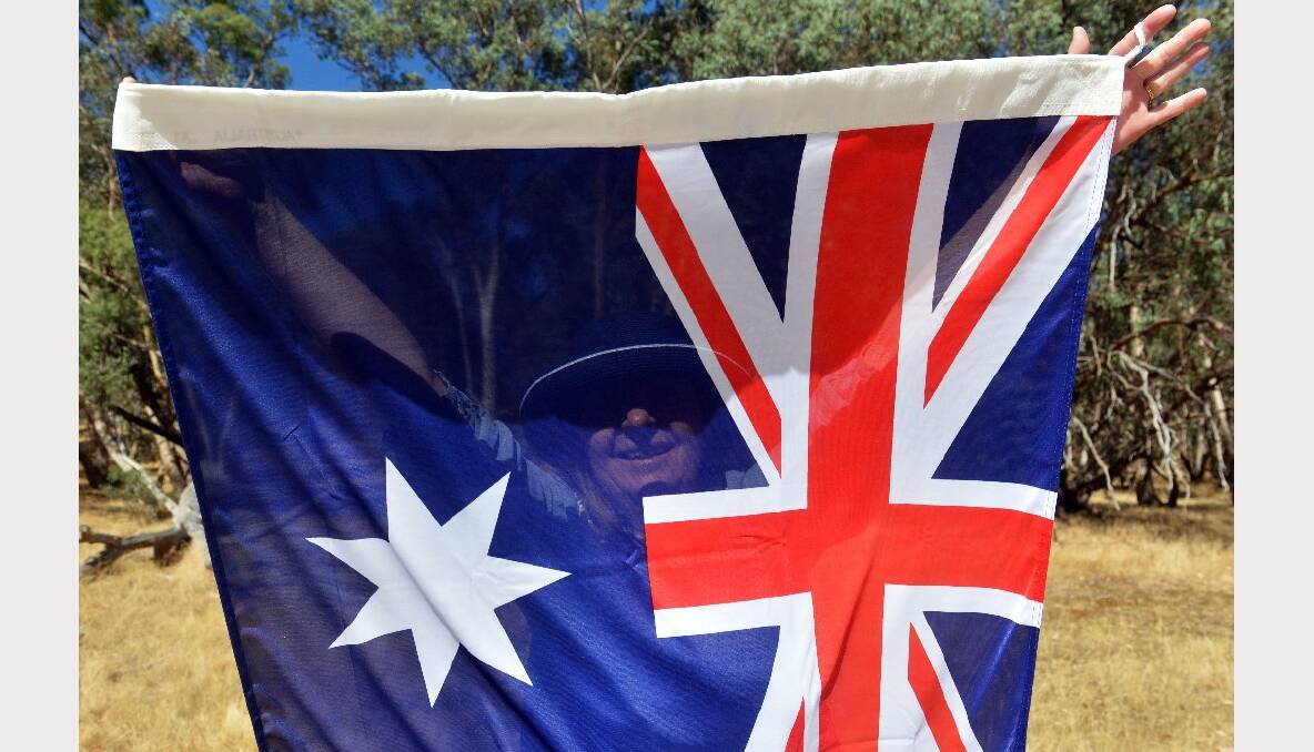 Australia Day celebrations in Faraday. Therese Horn unfurls the Australian flag. Picture: Brendan McCarthy