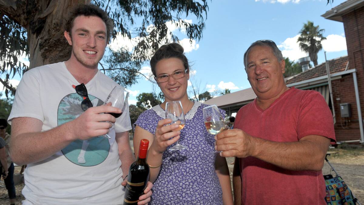 Josh Fagan and Ellen Cumming share a wine at Bridgewater's Water Wheel wine stand with Bob Craig from Echuca. Picture: Julie Hough