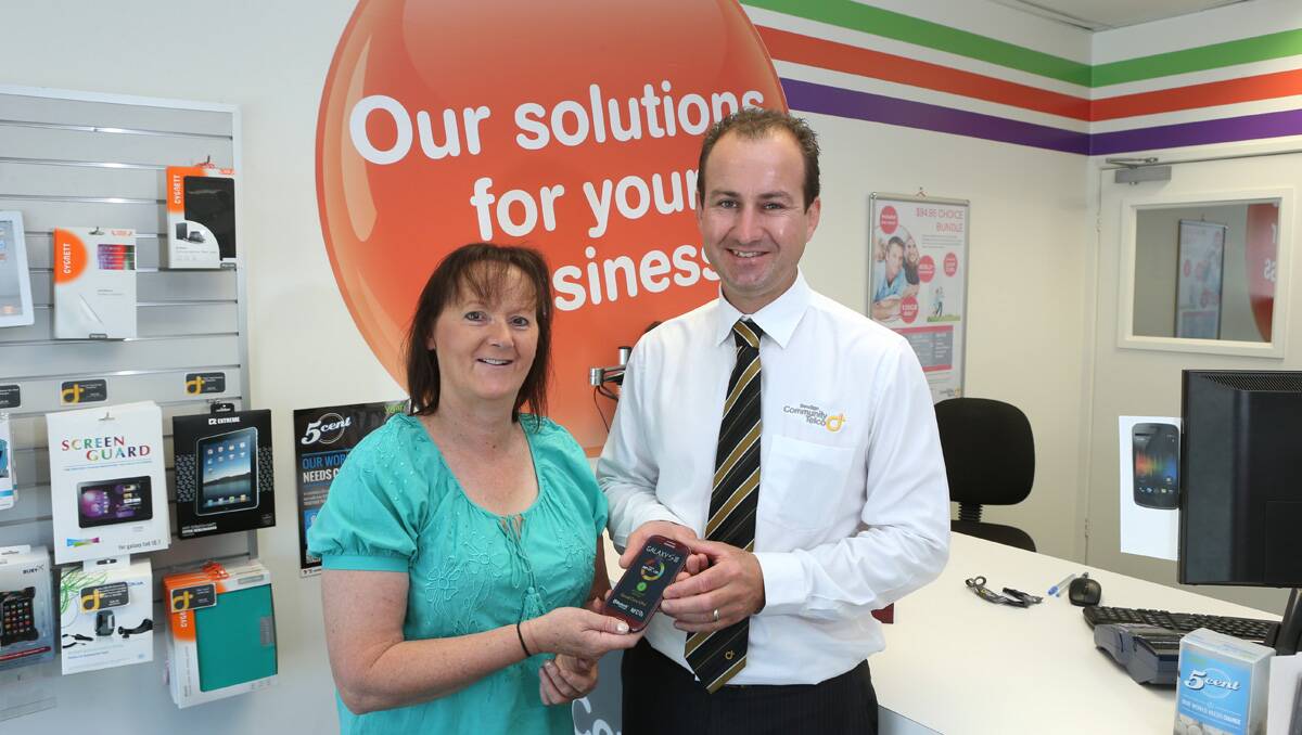 Lynne Nicolson is presented with her prized by Community Telco National Business Development Manager Phil Downing.