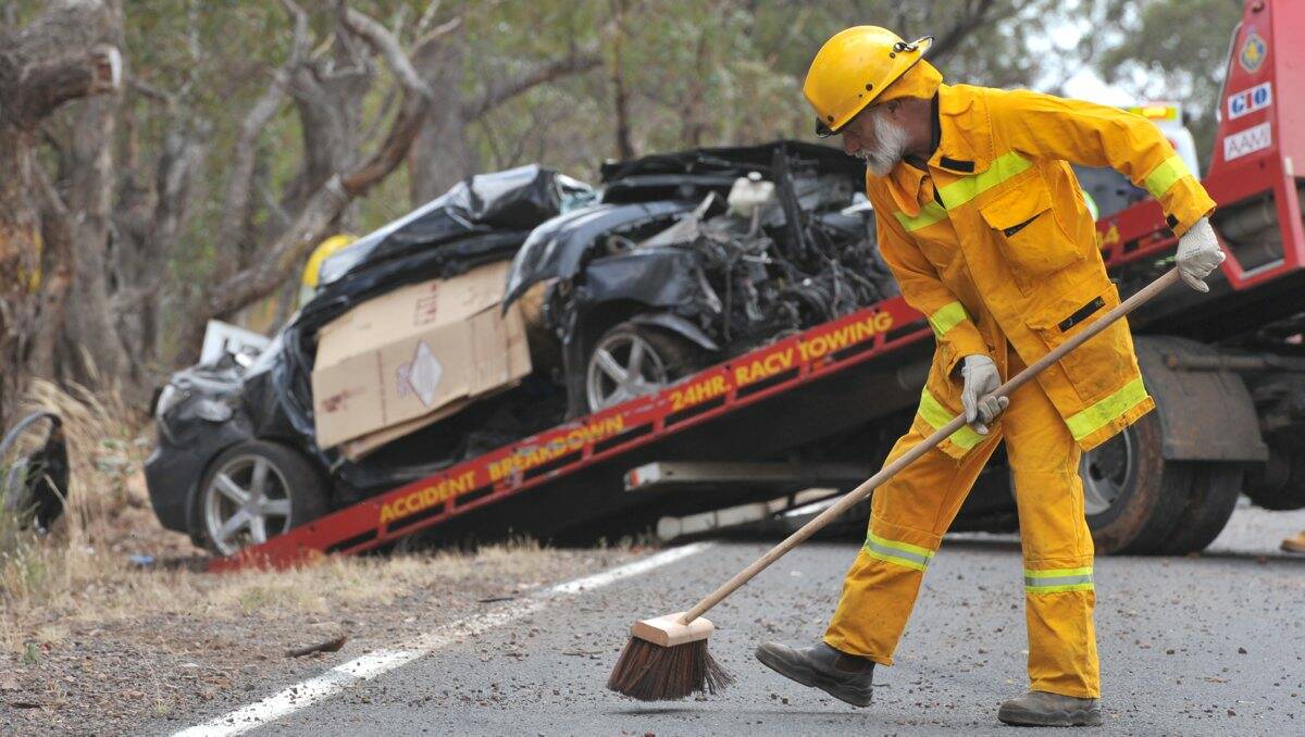CLEAN-UP: A volunteer firefighter clears up debris on the Heathcote-Rochester Road. Picture: BLAIR THOMSON
