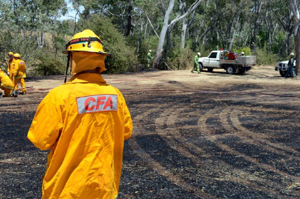 The CFA works to put out a grass fire in Sullivans Road, Strathfieldsaye, that was started by a lawn mower. Picture: JIM ALDERSEY