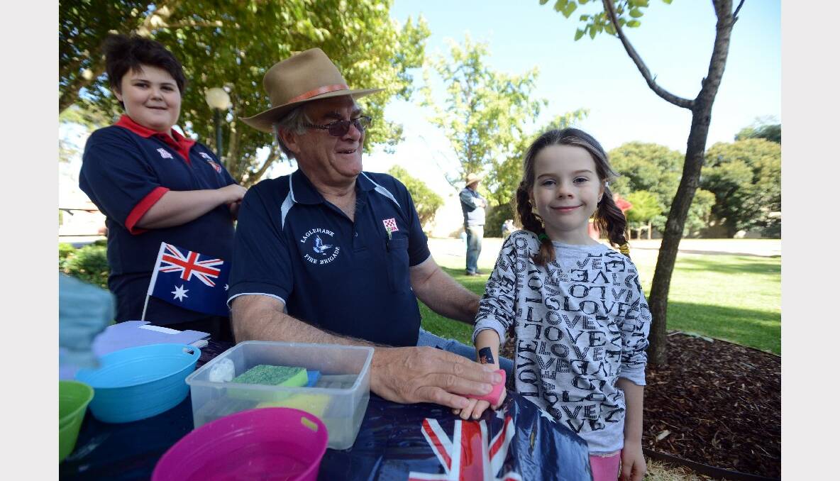 Australia Day celebrations in Eaglehawk. Eric Smith from the Eaglehawk CFA puts an Australian Flag tattoo on five-year-old Izzy Thomas. Picture: Jim Aldersey