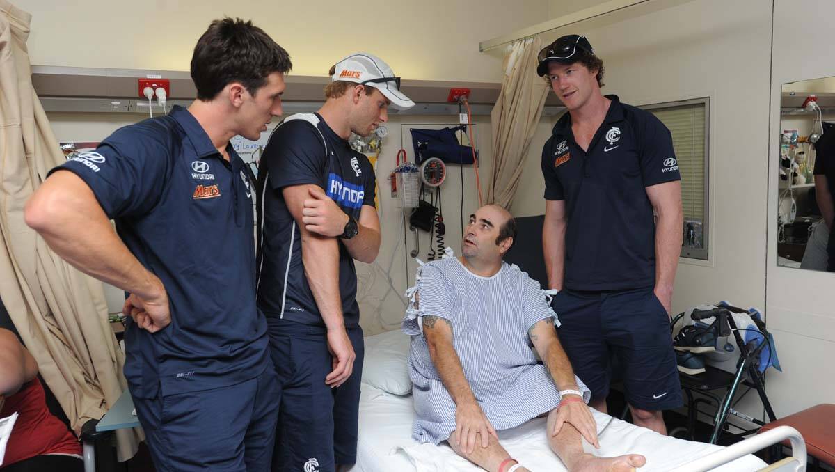 Carlton players visit Bendigo Health. Michael Jamison, Sam Rowe and Lachie Henderson visit Gary Laurence. Picture: Jodie Donnellan
